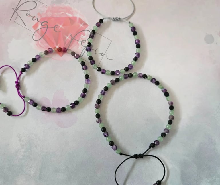 Four beaded bracelets with purple and black beads displayed on a light background with decorative text